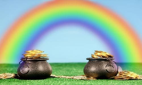 An image of two cast-iron pots filled with gold at the ends of a rainbow against a blue sky